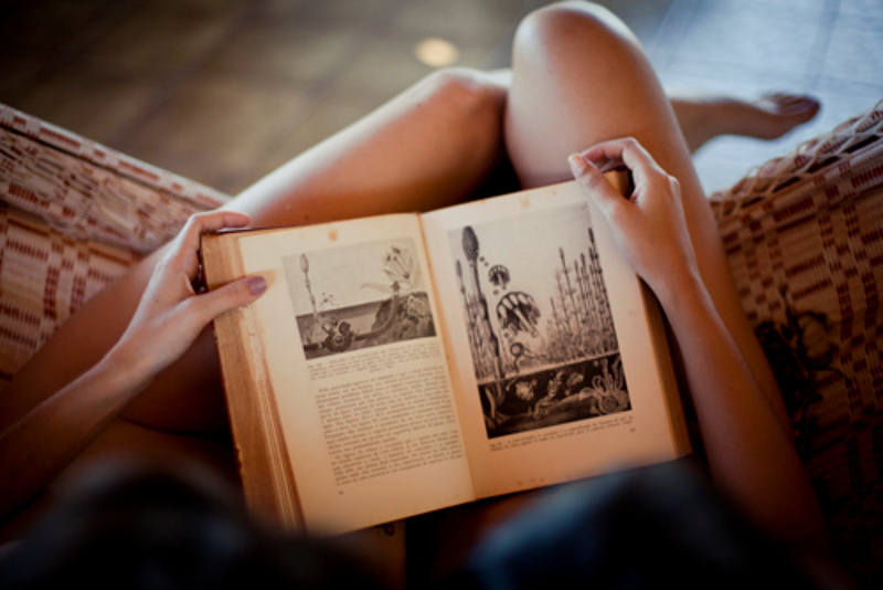 Девушка в очках читает книгу в трусах и чулках фото